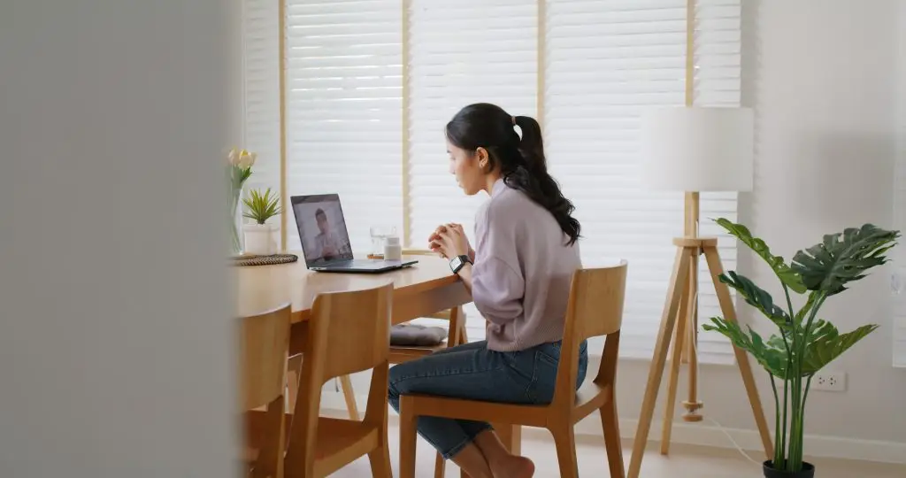 Woman participating in a virtual therapy session from home on her laptop